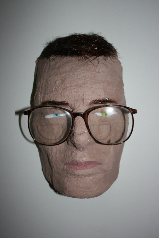 a papier mached face with glasses
