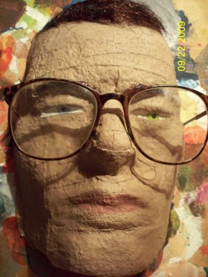 a papier mached face with glasses