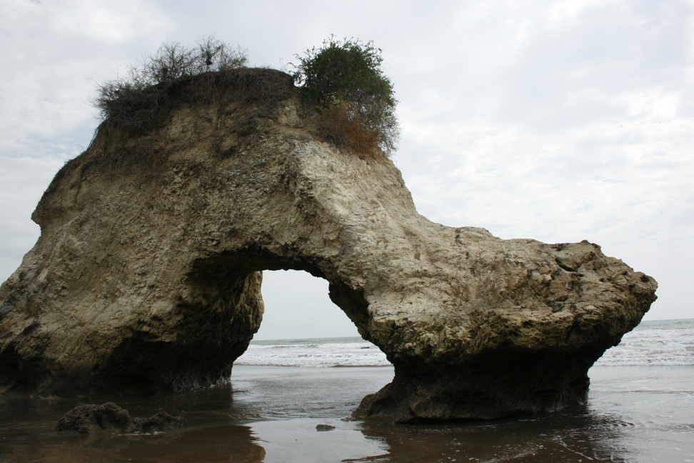 photograph of natural stone arch on beach in ecuador
